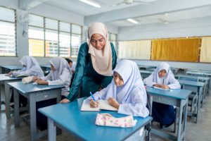 Teacher in the classroom attending an elementary class
